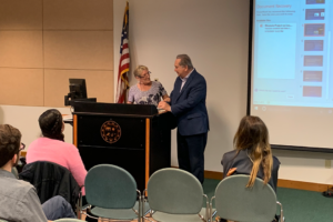 Professor of Modern and Classical Languages Patricia Miller introducing Robert Barbera at the Mentoris Project Symposium, March 2020.