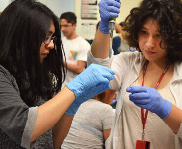 Two students from the BUILD PODER cohort in a lab setting