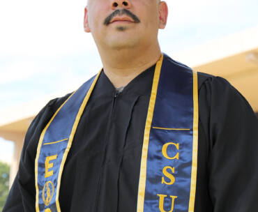 EOP Resilient Scholars Program alumnus Albert Martinez stands near the University Library.