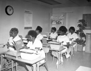 A vintage photo of a group of African American women sit in two rows for class at California Nursing School in Los Angeles.