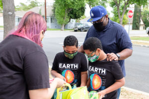 A family receives gift bags at the April 25 celebration of the Good Heart Chicana/o and Native Science project