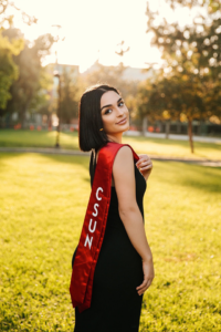 Graduating student Anie Attaryan in a grassy area of campus.