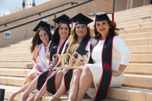 Graduating students pose for a group photo on the steps of the CSUN library.
