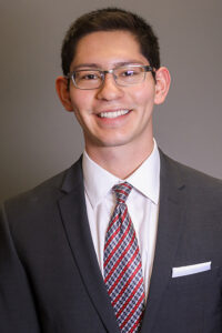 Head and shoulders portrait of Danny Bustos in suit and tie.