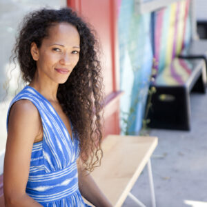 Portrait photo of CSUN Alumna Sybil Azur sitting on a bench.
