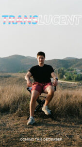 Avery is sitting on a chair with a desert in the background.