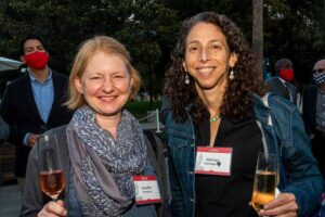 Two women pose for a photo. Each is holding a glass of rose.