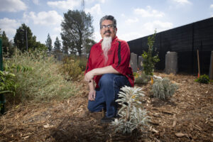Jesus Alvarez is kneeling in the center of the Institute's Garden.