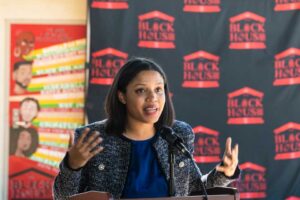 Dominique Moye speaks at a CSUN Black House backdrop.