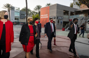 CSU Chancellor Joseph Castro walks past CSUN's University Student Union Northridge Center, with CSUN and CSU officials.