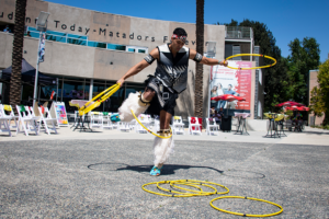 Dancer in Native American dress holds bright yellow hoop
