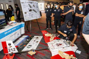 Poster boards in foreground with team members in background