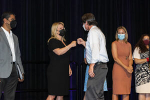 President Beck fist bumps award recipient