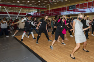 Attendees dance with President Erika D. Beck and Matty the Matador on the dance floor.