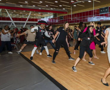 Attendees dance with President Erika D. Beck and Matty the Matador on the dance floor.