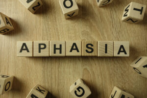 Scrabble letter tiles spell out "Aphasia"