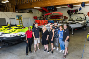 Dr. Erika D. Beck and faculty stand in front of power boats at CSUN Aquatic Center