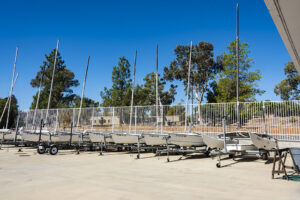 A line of sailboats on pavement.