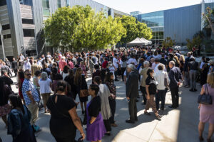 People stand in sunny courtyard at The Soraya