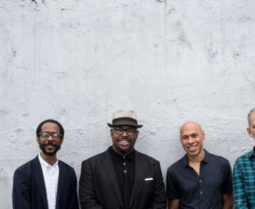 The quartet stands posing for the photo.