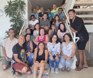 Founding members of FASA sit on a staircase and other huddle around, smiling for the photo.