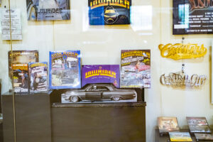 Glass exhibit case with "Lowrider" magazines in the foreground.