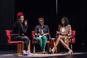Three women are seated on stage.
