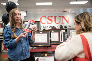 A representative talks a student through information regarding diploma frames.
