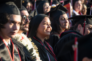 Graduate in cap and gown smiles with the sun on her face