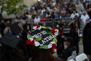 Mortarboard has red and white flowers with "Proud Latina" lettered in the center