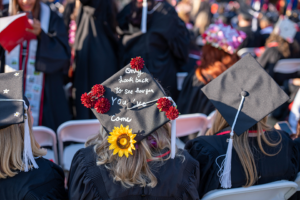 Red and yellow flowers decorate this mortarboard that says "Only look back to see how far you've come."