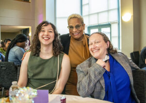 Debra Hammond, USU executive director, and Sarina Loeb, USU director of resource centers, sit with alumni at the CSUN Pride Center 10th anniversary gala.