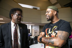 William Watkins, vice president of Student Affairs and dean of students, stands, talking with an alum in the USU Grand Salon.