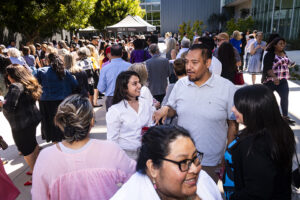 People standing in twos and threes as part of a larger crowd outside The Soraya.