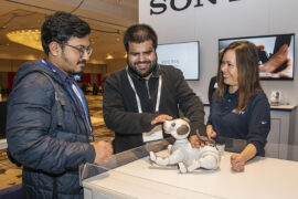 a group of people looking at a robot dog