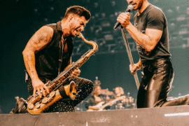 a person playing a saxophone with another person on stage