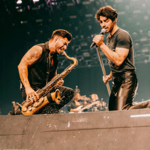 a person playing a saxophone with another person on stage