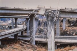 a damaged bridge with a road and a winding road