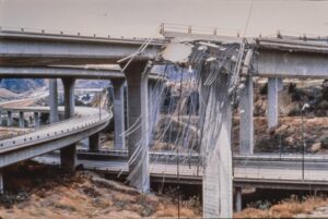 a damaged bridge with a road and a winding road