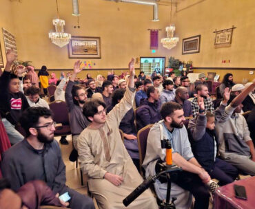 CSUN Muslim Student Association members raising their hands at a mosque.