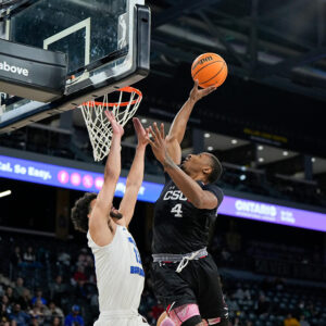Men's basketball forward Keonte Jones skies over a UCSB player at the basket.