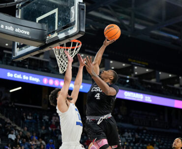 Men's basketball forward Keonte Jones skies over a UCSB player at the basket.