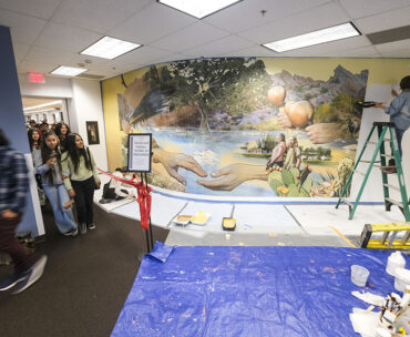 Students walk by the mural.