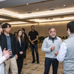 Marty Chavez stands at the center of a group of students, talking to one student.