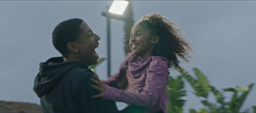 A man holding a girl in the air and laughing.