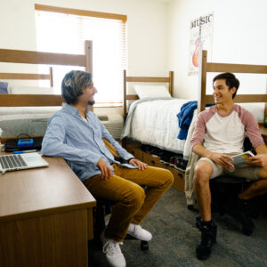 Two CSUN students talking to each other in their dorm room.