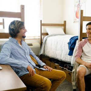 Two CSUN students talking to each other in their dorm room.