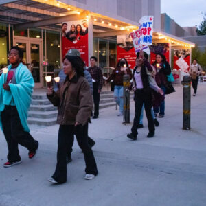 CSUN students march through campus with lights and protest signs.