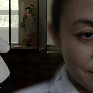 A man making a funny face while looking over the shoulder of a woman.