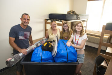A family poses with their college student moving her into the CSUN dorms.